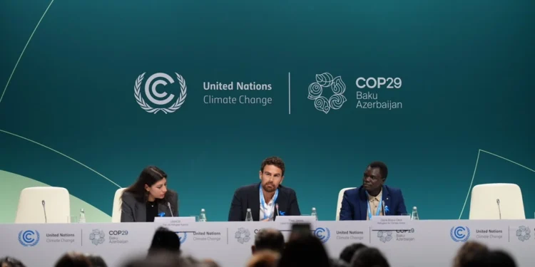 Actor and UNHCR Goodwill Ambassador Theo James (centre) and refugee climate activist Opira Bosco Okot (right) at the launch of the "Refugees for Climate Action" network at COP29 on Thursday.